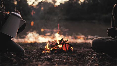 People Pouring A Warm Drink Around A Campfire Free Stock Video