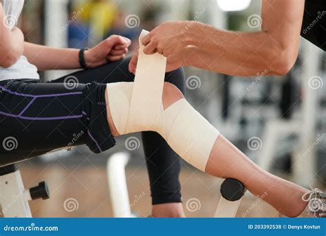 Close Up Man Wrapping Bandage On Womans Leg In Gym Stock Photo Image