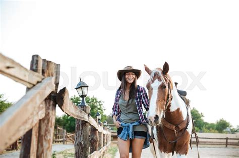Happy Beautiful Young Woman Cowgirl With Her Horse On Ranch Stock