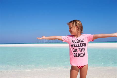 Прелестная маленькая девочка играя в море на пляже Стоковое Изображение изображение