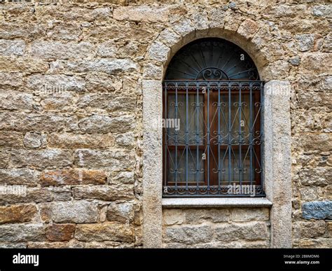 Arched Window And Ancient Wall Built With Stones Of Various Types And