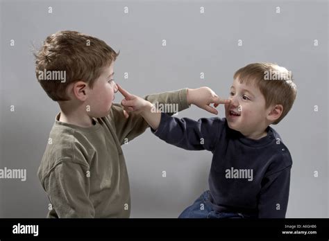 Two Young Boys Playing And Touching Each Others Noses With Their