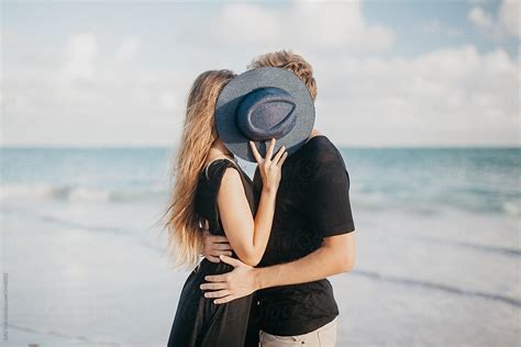 Couple Kissing And Hiding Behind Hat By Stocksy Contributor Julia Volk Stocksy