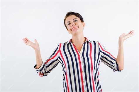 free photo mature woman showing helpless gesture in striped blouse and looking powerless
