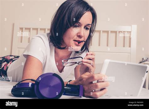 mujer joven sentada en la cama y leyendo un libro fotografías e imágenes de alta resolución alamy