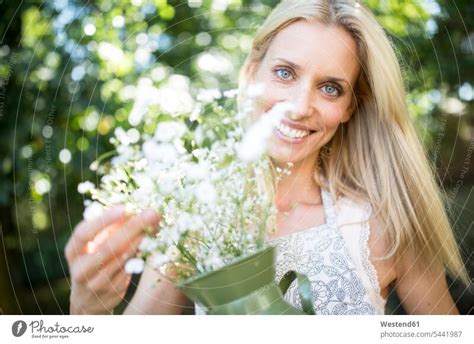 Lächelnde Frau Hält Krug Mit Blumen Im Freien Ein Lizenzfreies Stock Foto Von Photocase