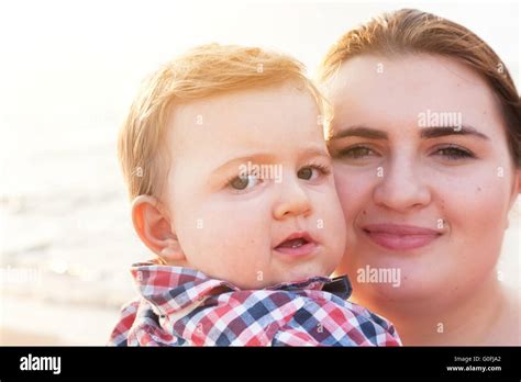 Young Mother Holding His Child On The Beach Having Fun Together Son