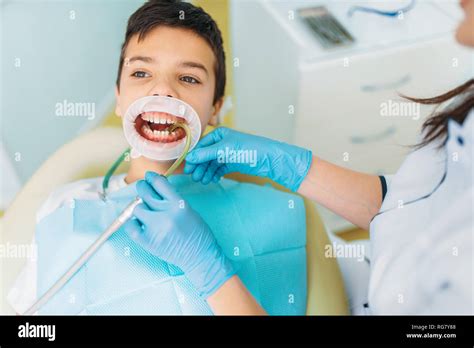 Little Boy In A Dental Cabinet Caries Removal Procedure Pediatric