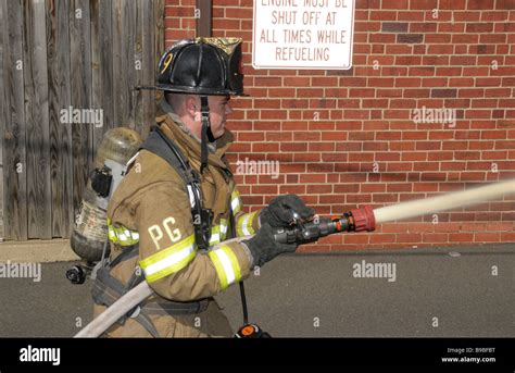 Firefighter Holding A Hose Line Stock Photo Alamy