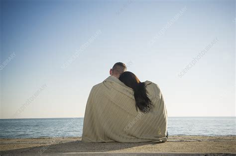 couple wrapped in blanket on beach stock image f006 4319 science