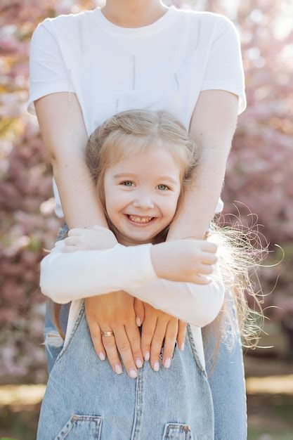 La Hija Abraza Las Manos De Su Madre En El Parque Cerca Del Sakura