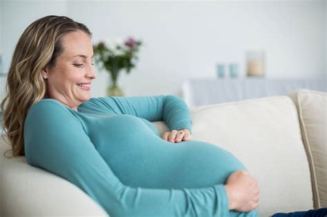 premium photo pregnant woman touching her belly lying on the couch