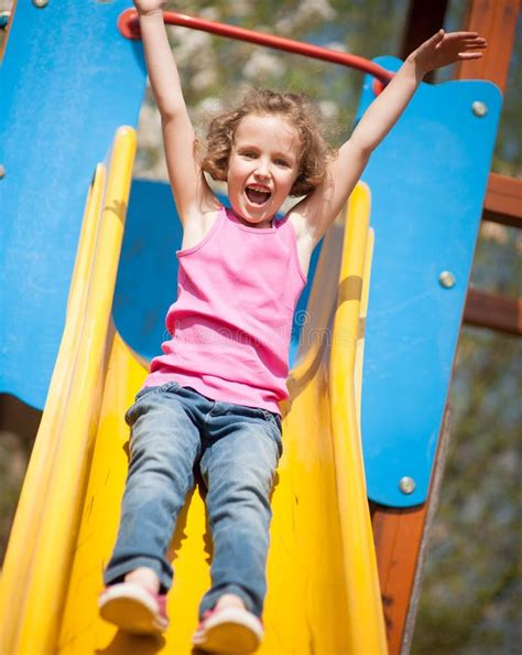 Close Up View Of Young Girl On Slide In Playground Stock Photo Image