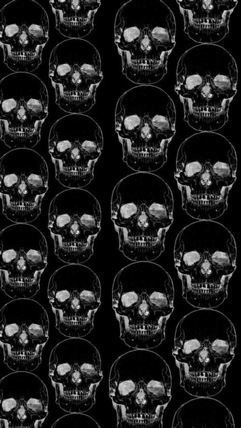 A Bunch Of Skulls That Are In The Middle Of Black And White Paper With