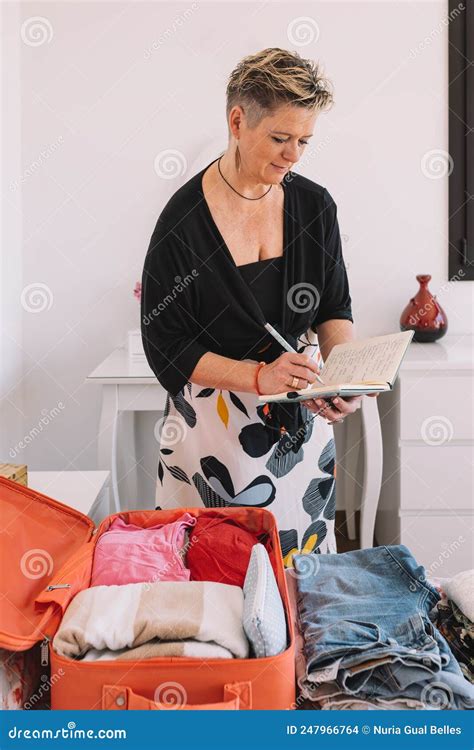 Mature Businesswoman Organising Her Luggage For A Business Trip Mature Woman Packing Her