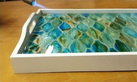 A White Tray With Blue And Green Glass In It Sitting On A Table Next To