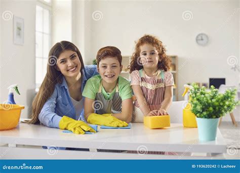 Família Feliz Com a Mãe E Duas Crianças Limpando Em Casa Pais E