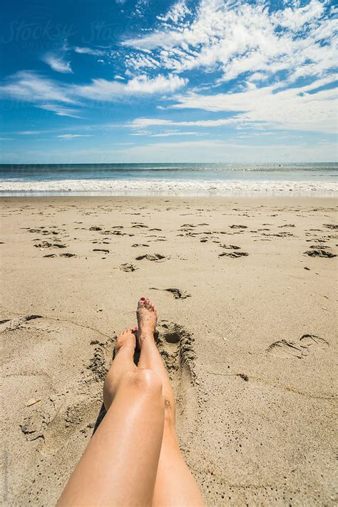 Woman Sunbathing Alone On The Beach Stocksy United