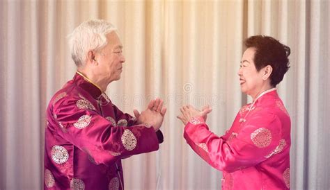 Asian Senior Couple Celebrate Chinese New Year In Red Traditional