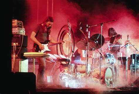 Pink Floyd Playing On The Stage Surrounded With A Smoke And Illuminated