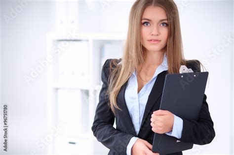Pretty Brunette Business Lady In The Office In A Black Jacket Holding