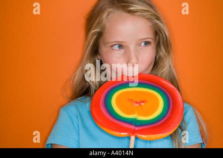 Girl Licking A Colourful Lollipop Stock Photo Alamy