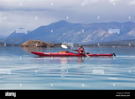 Young Woman In A Sea Kayak Paddling Sea Kayaking Mountains Behind