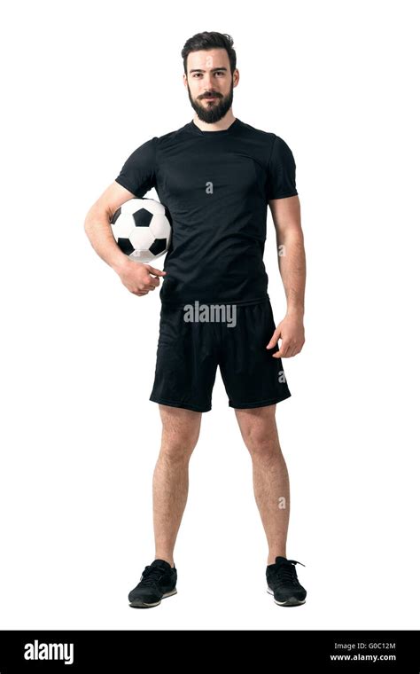 Smiling Soccer Player Holding Ball Under His Arm Looking At Camera