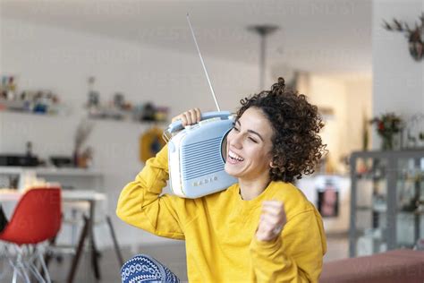 Carefree Woman Listening To Music With Portable Radio At Home Stock Photo