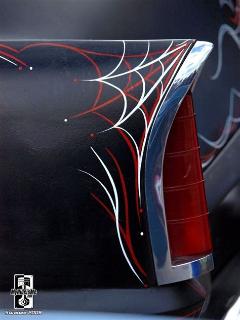 The Back End Of A Black Car With Red And White Designs On Its Side