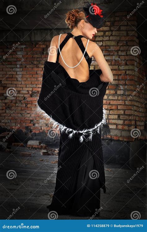 Элегантная женщина в черных платье и шляпе с вуалью Стоковое Изображение изображение