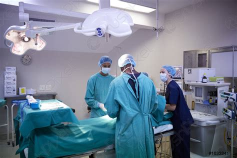 Surgical Team Working On Patient In Hospital Operating Theatre Stock