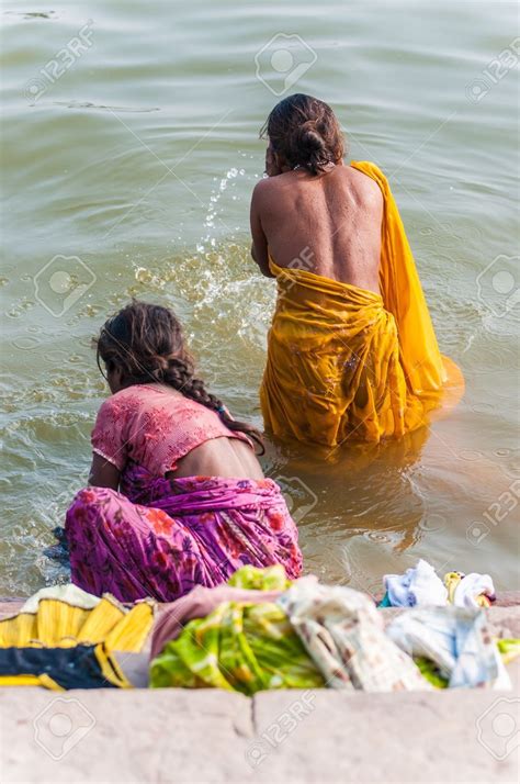 Two Women In Sari Bathing In The River With Their Backs Turned To One Another
