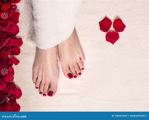 Beautiful Female Feet On Terry Towel With Rose Petals Jar And Tube Of