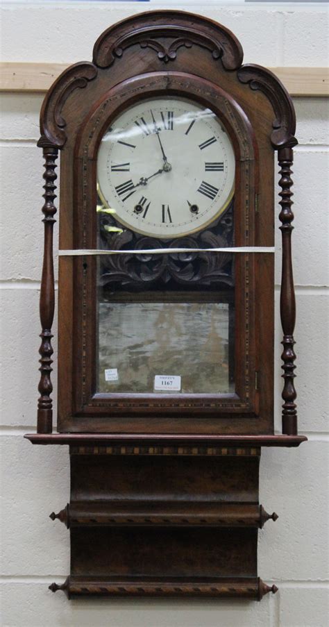 A Late 19th Century American Walnut Cased Wall Clock The Movement Striking On A Gong The Case With