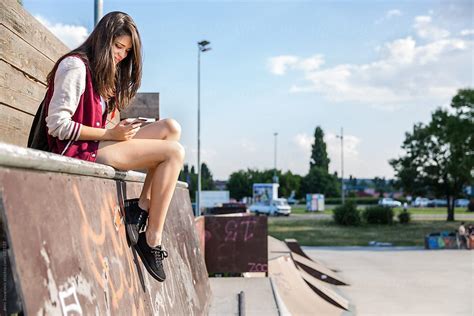 Ver Girl Sitting In A Skate Park Checking Her Phone Del Colaborador