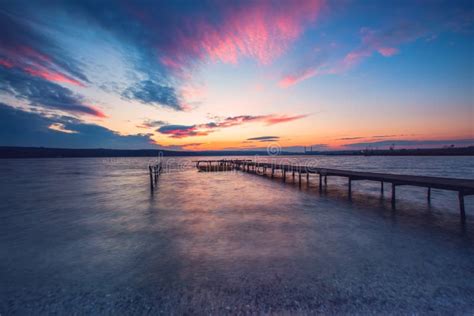 Wooden Dock And Fishing Boat At The Lake Sunset Shot Stock Photo