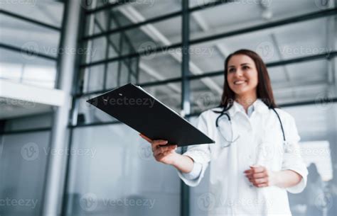 Giving Notepad Young Nurse Indoors In Modern Clinic Conception Of