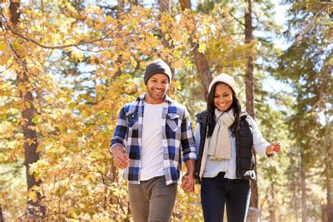 African American Couple Walking Through Fall Woodland Stock Photo