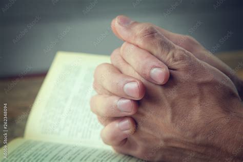 Praying Hands Over A Holy Bible Stock Photo Adobe Stock