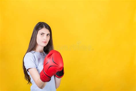 Confident Young Woman With Red Boxing Gloves Stands In Fighting Stance