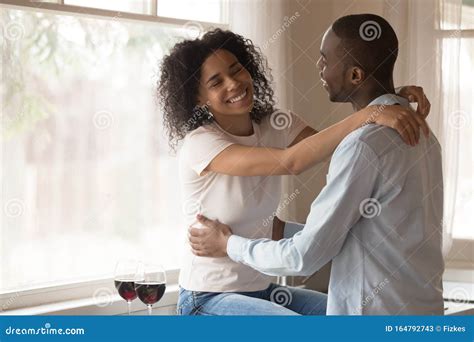 Happy Biracial Couple Hug Enjoying Romantic Date At Home Stock Image