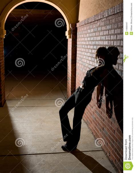 Jeune Femme Se Penchant Contre Le Mur De Briques La Nuit Image Stock