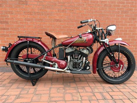 A Red Motorcycle Parked Next To A Brick Wall