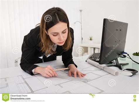 Close Up Of Female Architect With Blueprint On Desk Stock Photo Image