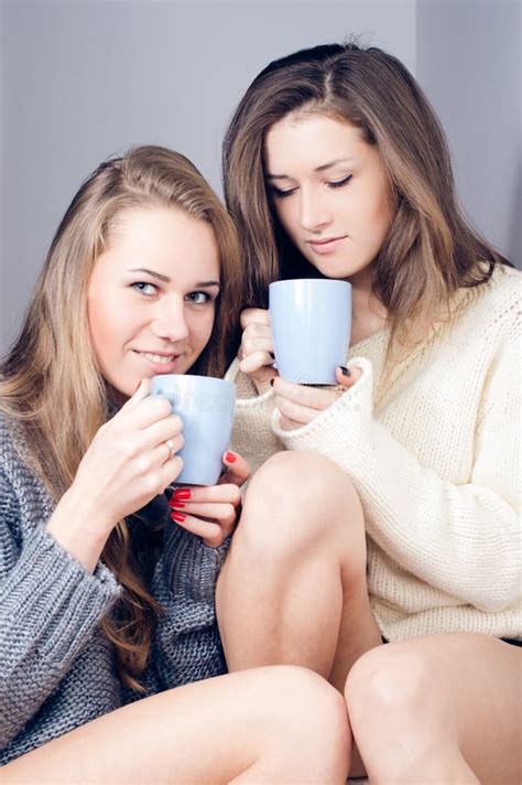 two happy girlfriends drinking tea together stock image image of blond angora 37272749