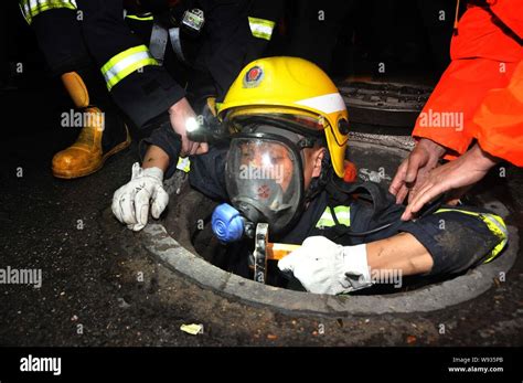 A Chinese Firefighter Is Pulled Out Of A Drainage Hole After A Search