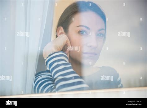 Woman Looking Through Window Stock Photo Alamy