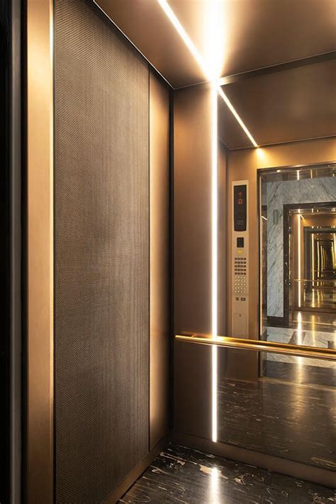 An Elevator With A Mirror And Lights On The Wall Next To Its Doors