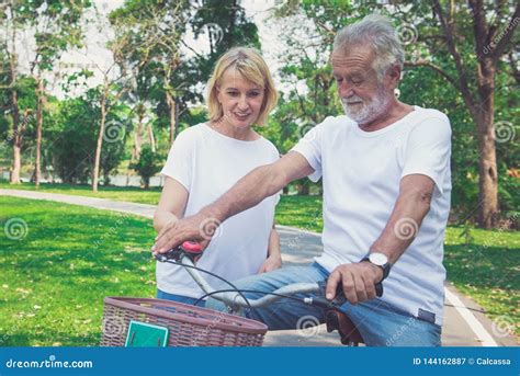 Pares Felices De La Anciano Que Montan Una Bicicleta En El Parque